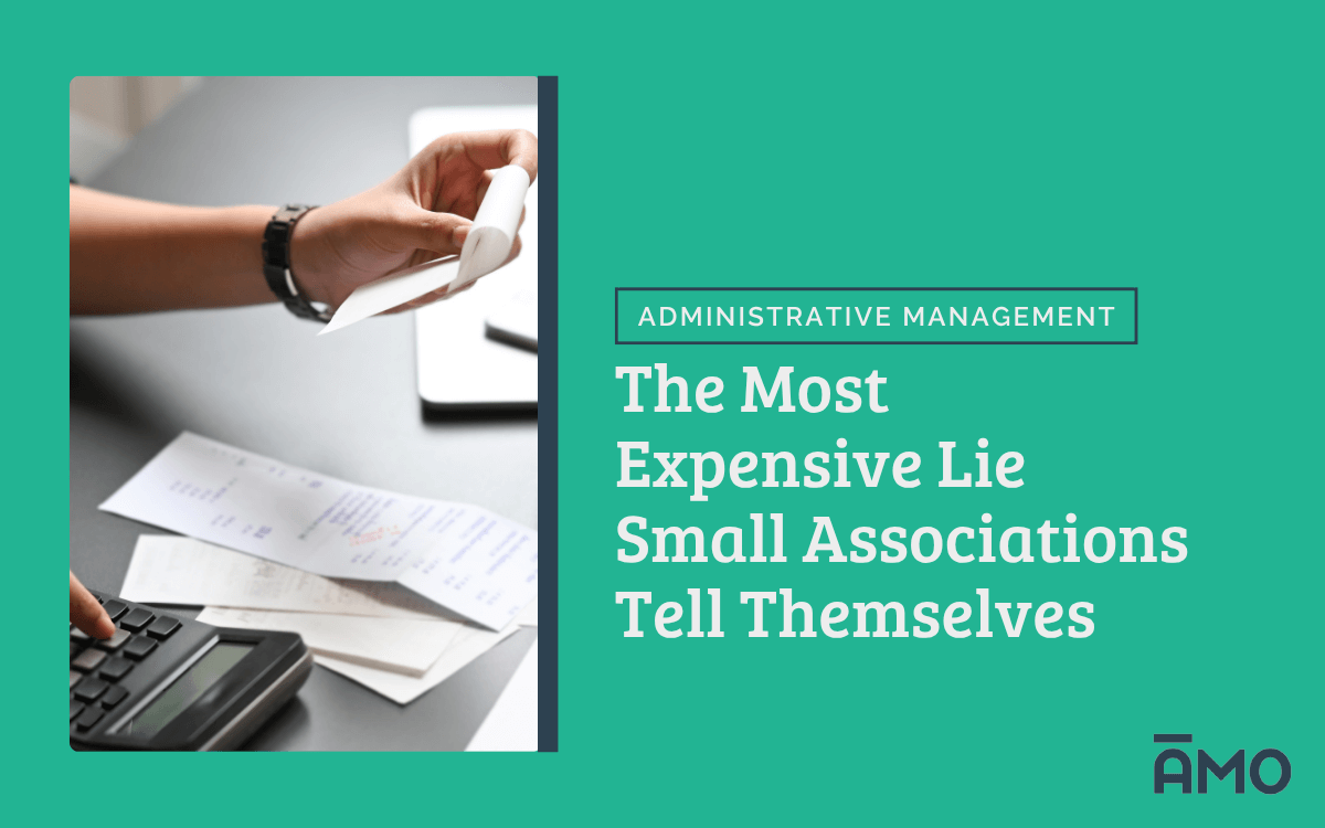 Close-up of a person using a calculator and handling paper receipts or invoices, with a laptop in the background. On the right, bold text reads “The Most Expensive Lie Small Associations Tell Themselves” under the category “Administrative Management,” with the AMO logo in the corner.